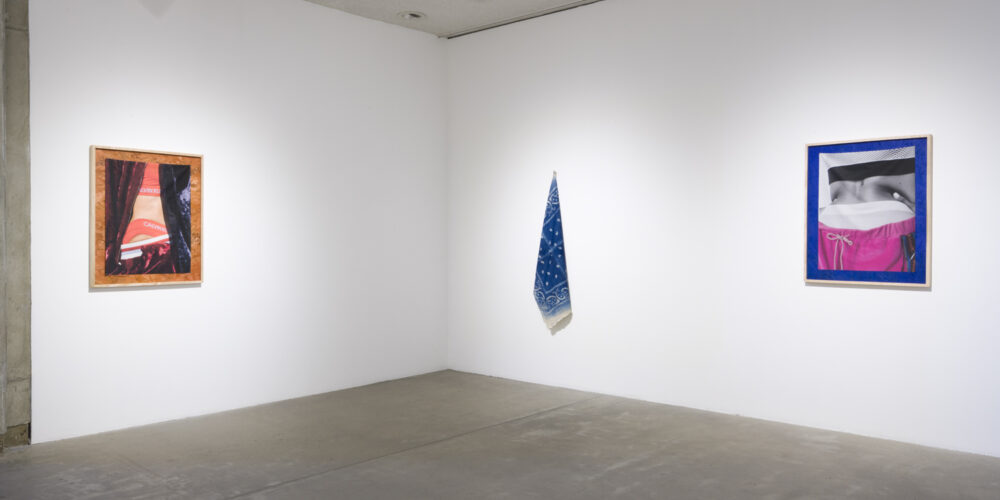 In this artwork installation by the artist David Alekhuogie, one artwork hanging on the wall depicts a photographed side view of a female model showing off her bra and underwear that says "Calvin Klein". There is also a dark burgundy and dark blue fabric pictured as the background. This photograph is placed on a cork board. To the right of this artwork is a large, blue bandana hanging from the wall. To the right of this work is an artwork depicting a photographed back side of a female model with her hands on her lower back. She's wearing hot pink sweatpants, and underwear and a bra that says "Calvin Klein". This photograph is placed on top of a cobalt-blue painted cork board.